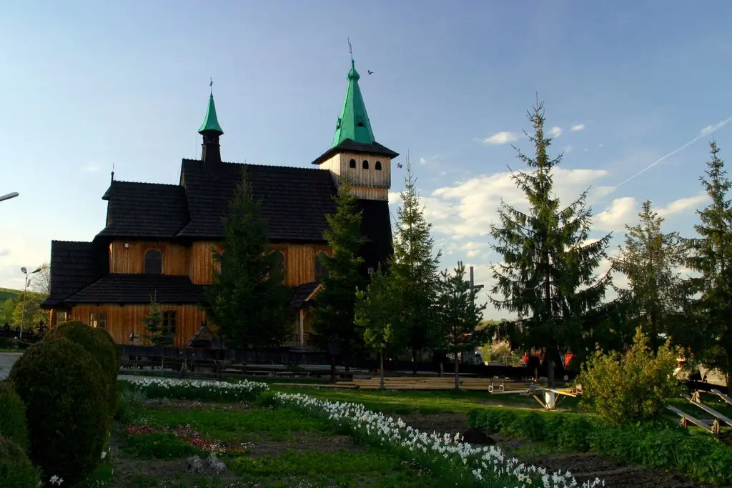 Kościół w Witowie z ogrodem i smrekami w słońcu