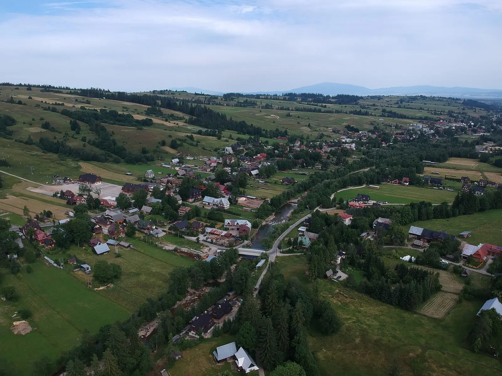 Witów z lotu ptaka: zabudowa wzdłuż drogi i pola u stóp Tatr